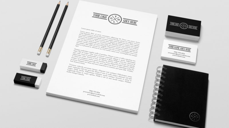 Pennor, sudd, papper, visitkort och anteckningsbok som förslag till design.