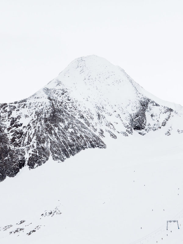 Snötäckt berg med skidlift i alpin miljö.