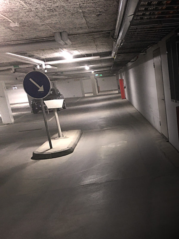 Belyst garage med en tydlig blå trafikskylt