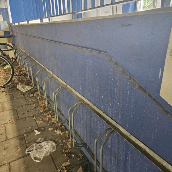 Smutsig blå vägg med cykelställ i garage innan rengöring